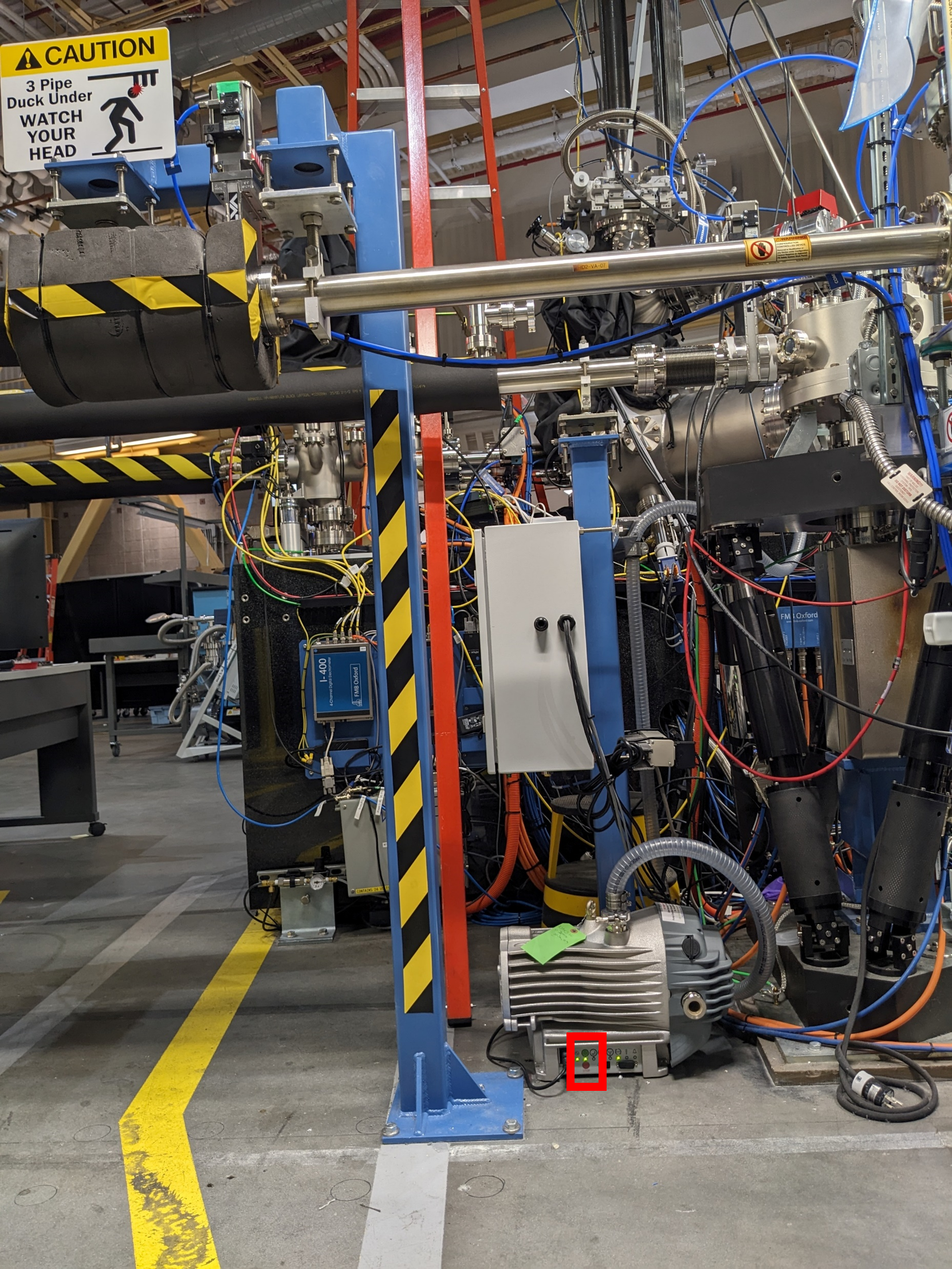 Inboard side of SST2 and SST1 beamline, where backing pump for SST1 RSoXS solid sample load lock is located. Red box: press and hold the red and green buttons to turn off and on the backing pump, respectively.